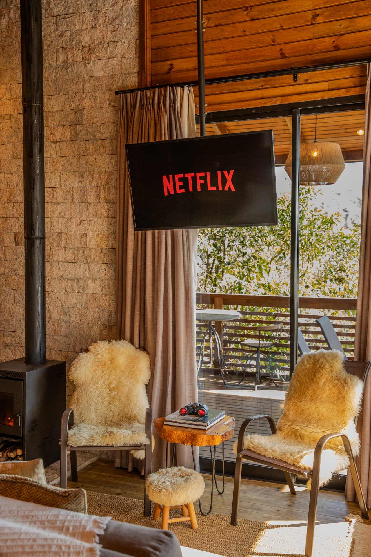 Sala com televisão, lareira e varanda